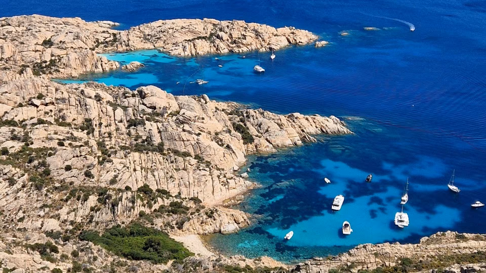 Stunning aerial view of Cala Coticcio's azure waters and rugged coastline on Caprera Island.