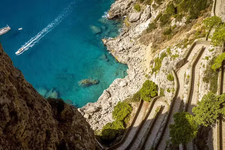 Scenic view of winding coastal paths and turquoise waters on Capri Island, ideal for a guided tour with Blue Grotto visit.