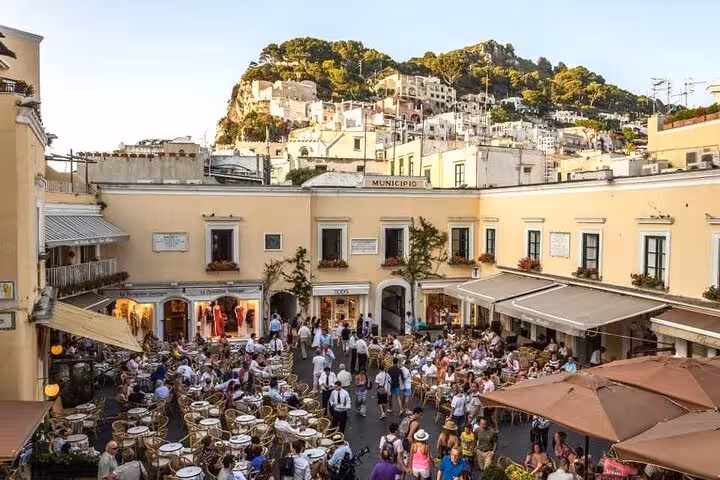 Vibrant Capri town square bustling with tourists, cafes, and scenic views on a full-day hydrofoil tour from Amalfi.