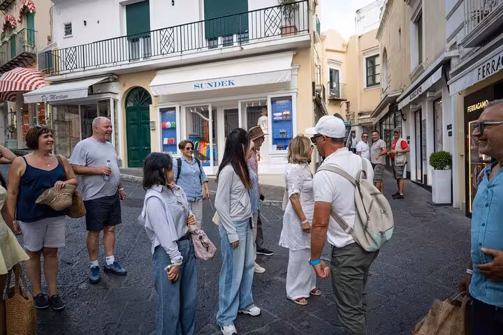 Tourists explore the charming streets of Capri during the Blue Grotto and Faraglioni guided tour from Naples.