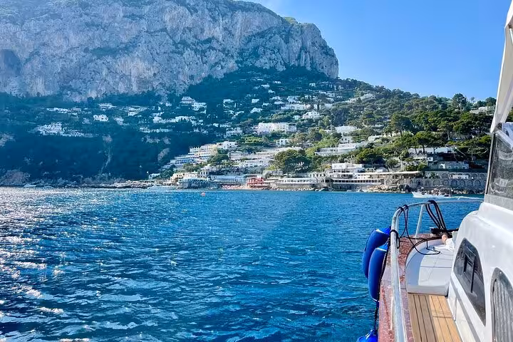 Scenic boat ride approaching Capri's stunning coastal cliffs and charming hillside villas from Amalfi.