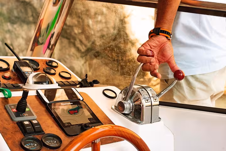 Boat captain expertly navigates the scenic Capri waters on a small group excursion from Sorrento.