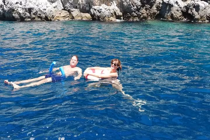 Guests enjoy floating in the clear blue waters during a Capri boat excursion from Sorrento.