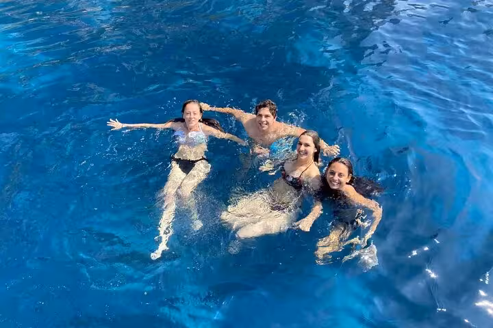 Group of friends enjoying a swim in the crystal-clear waters during an afternoon Capri boat tour.