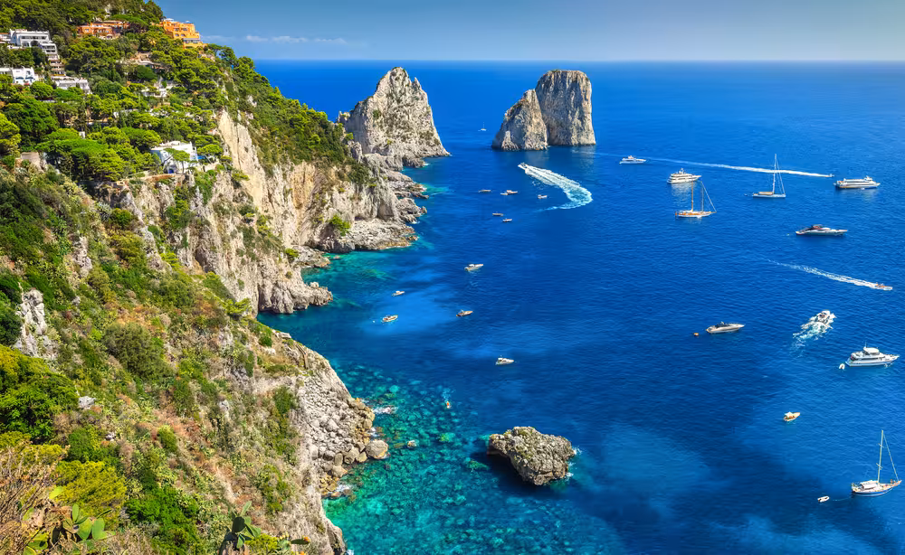 Stunning view of Capri's iconic sea stacks and vibrant coastline on a sunny boat tour from Naples.