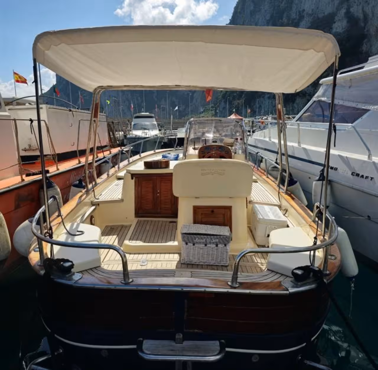 Private Capri boat tour deck at Marina Grande harbor, classic wooden gozzo ready for one-day cruise