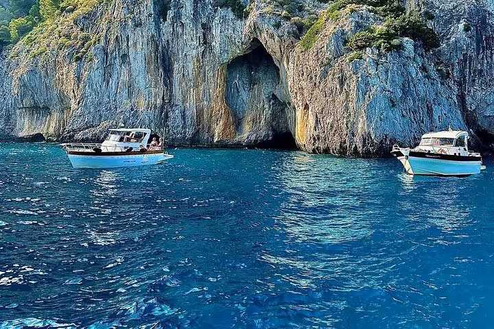 Two boats near the stunning cliffs and turquoise waters of the Capri coastline, perfect for swimming and exploration.