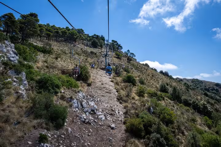 Scenic chairlift ride over Capri's lush landscape during a guided island exploration tour.