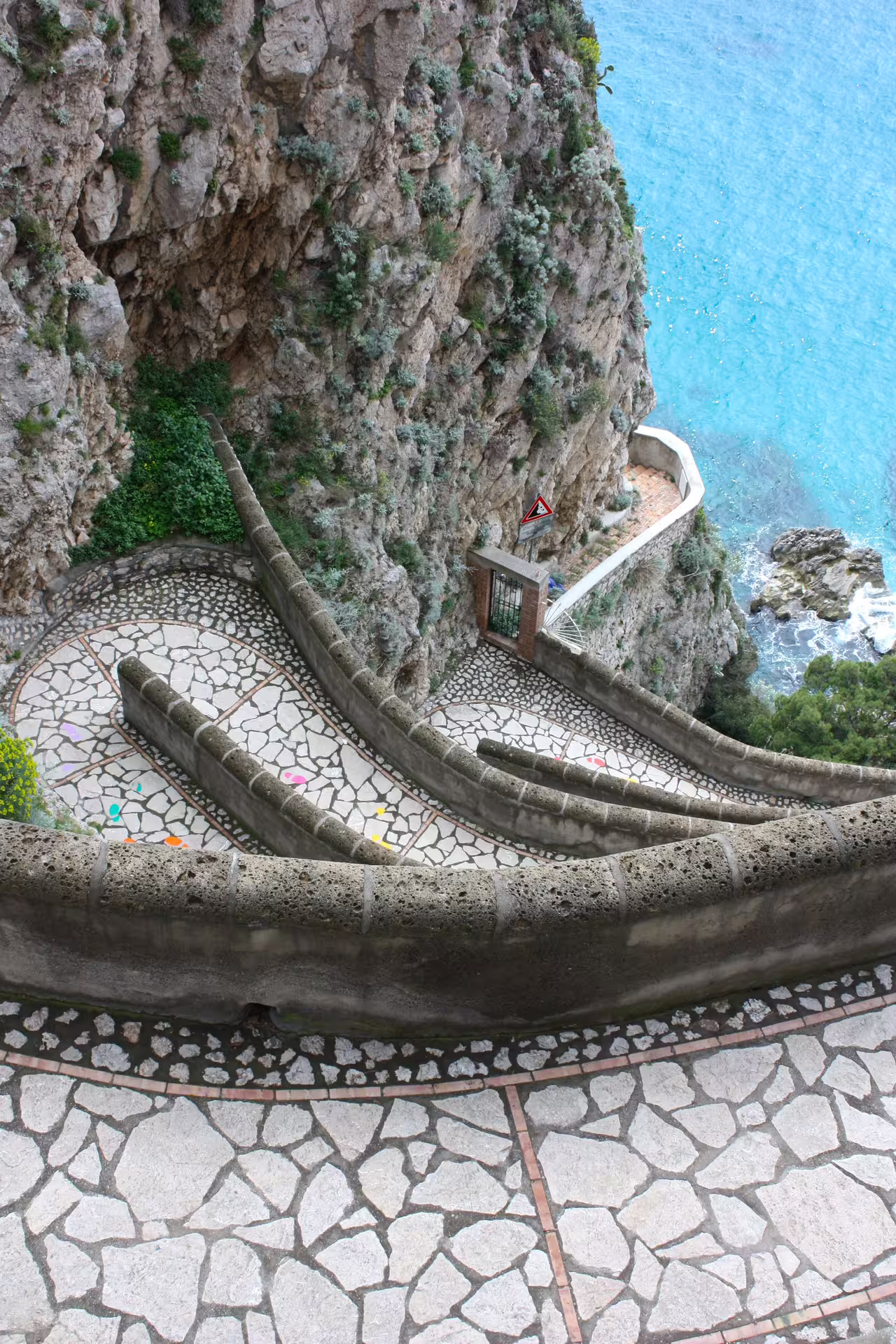 Scenic stone pathway winding down Capri’s cliffside above turquoise Amalfi Coast waters on Italy of the Emperors tour