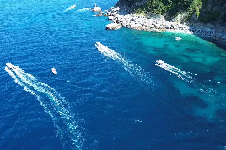 Aerial view of boats cruising turquoise Capri waters on a 3-hour private classic gozzo island tour