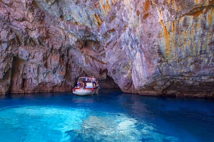 Small boat entering a stunning cave with turquoise waters during a Capri Island excursion from Sorrento.