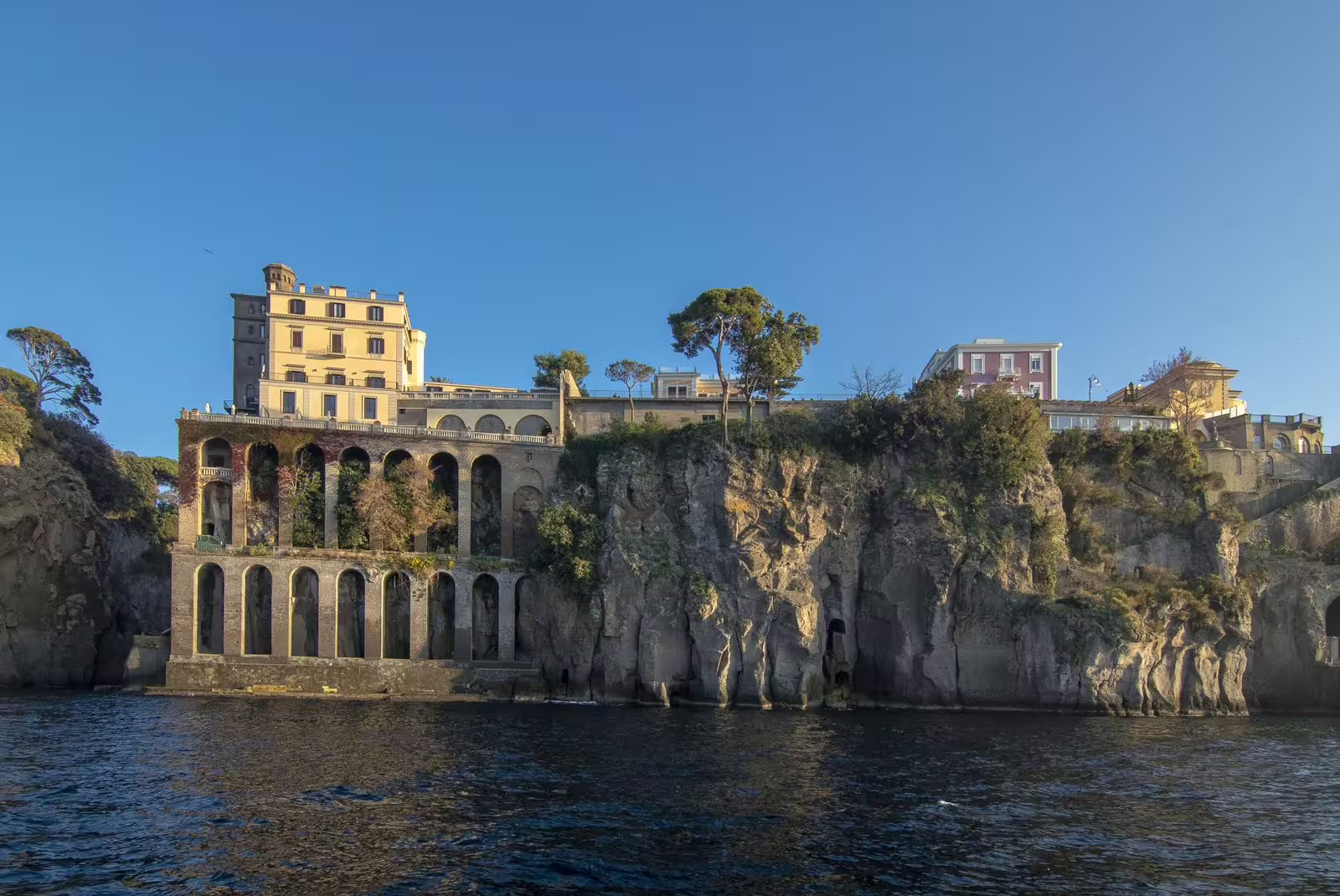 Scenic view of historic buildings perched on cliffs along the stunning coastline of Capri Island.
