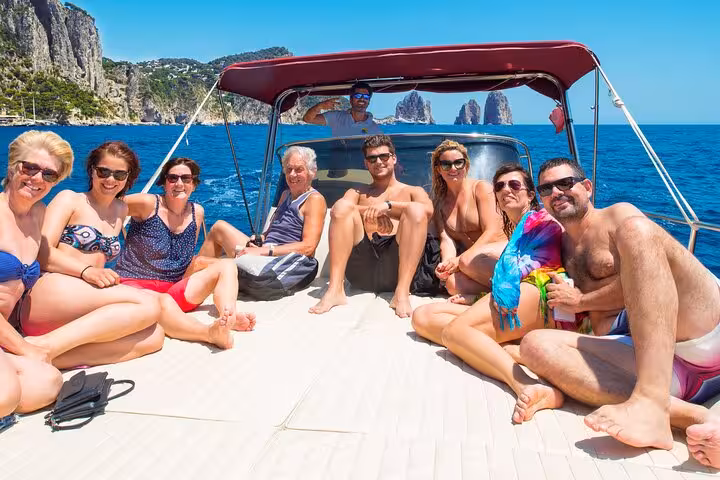 Group enjoying sun on a Capri Island boat tour from Naples with stunning sea views.