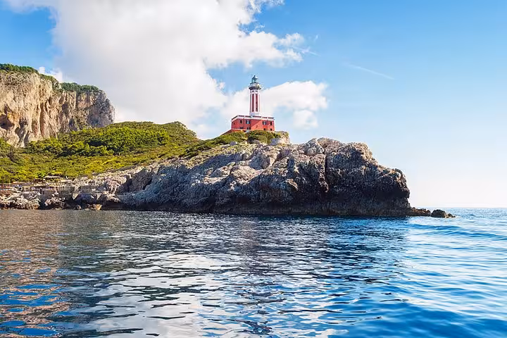 Picturesque Punta Carena Lighthouse on Capri Island viewed from the sea during a small group boat tour.