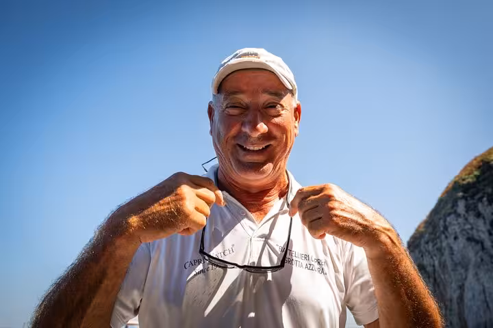 Smiling guide ready for the Capri island tour, showcasing local hospitality under clear blue skies.