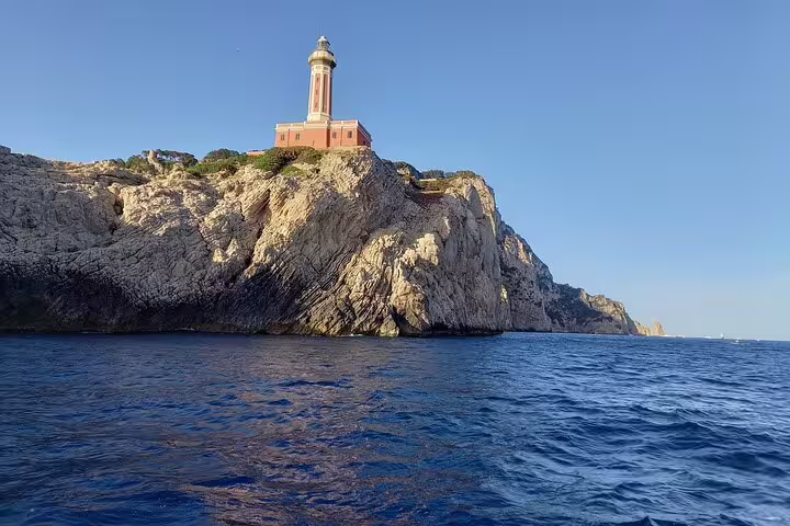 Capri lighthouse on rocky cliffs above the Tyrrhenian Sea, view from a 2-hour private boat tour cruise