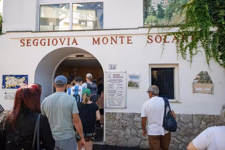 Visitors entering the Seggiovia Monte Solaro for a scenic ride during a full-day Capri island exploration tour.