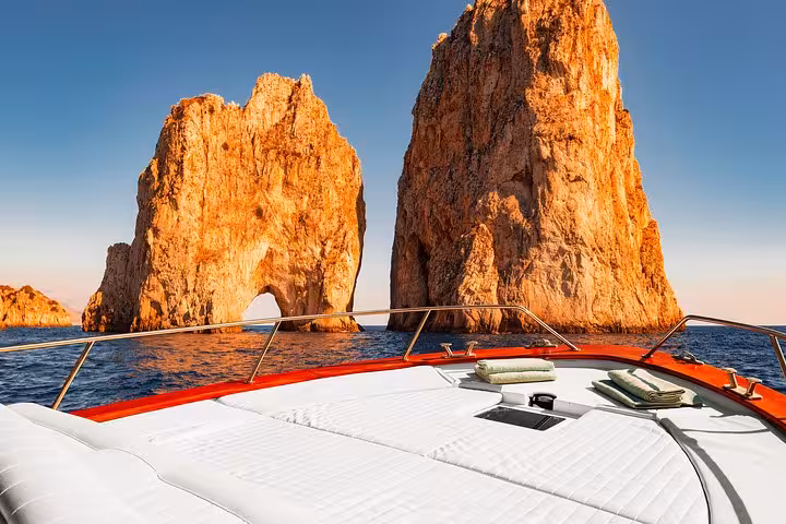 Luxurious boat tour near Capri's iconic Faraglioni rocks on the Gozzo Apreamare 10 from Sorrento.
