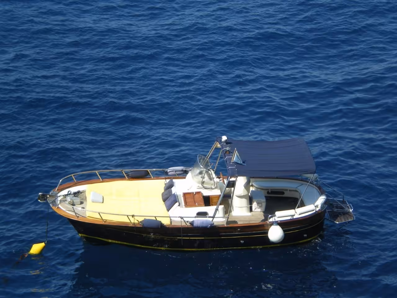 Private motorboat anchored in the Tyrrhenian Sea on a Capri one-day boat tour, ideal for sightseeing stops