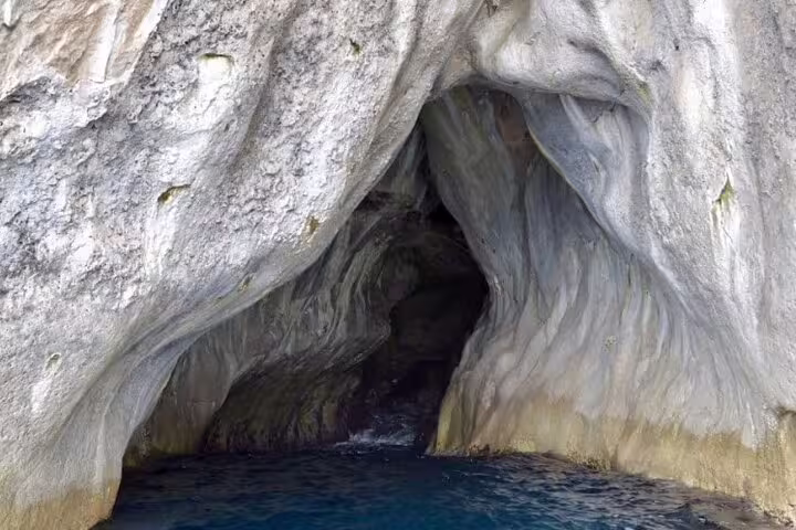 Sea cave on Capri coastline viewed by private classic gozzo, ideal stop on 3-hour island boat tour