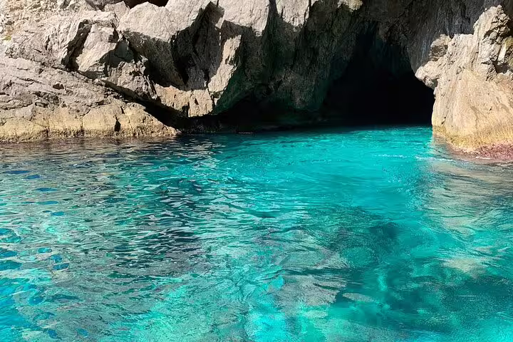 Hidden sea cave and rocky cove with turquoise water, stop on Private Boat Tour Sea Day Charm and Freedom