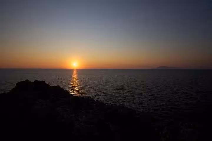 Serene sunset view over the Mediterranean Sea from Sorrento's exclusive Capri boat tour, with calming ocean reflection.