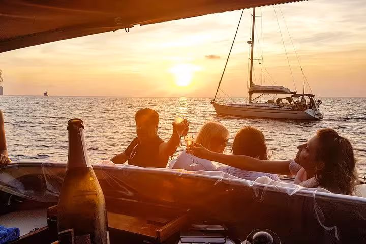 Group enjoying a sunset toast on a boat during the Capri Sunset Escape tour from Sorrento.