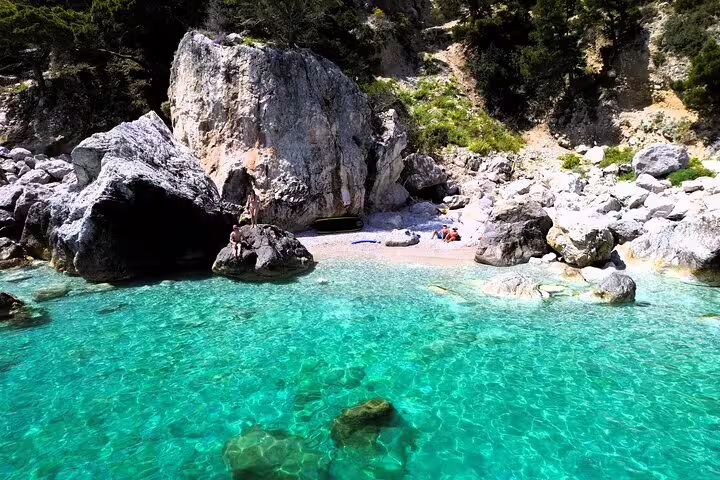 Secluded turquoise cove stop on a private full-day boat tour, rocky beach for swimming and snorkeling break