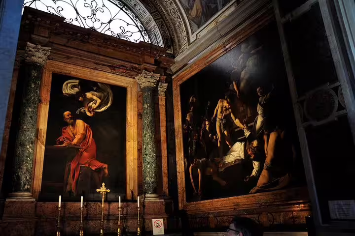 Caravaggio Baroque masterpieces illuminated in a dim Roman church, visited on a Rome private art history walking tour