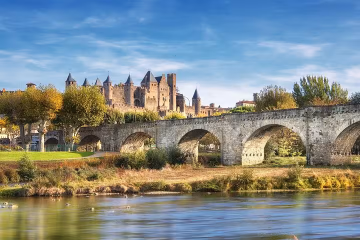 Beautiful view of Carcassonne Fortress and the old stone bridge over a tranquil river.