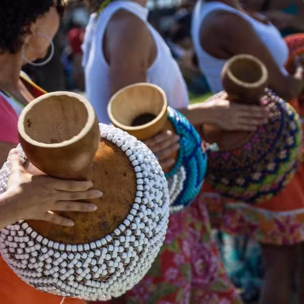Participants playing traditional instruments at a vibrant bloco de rua during a lively carnival street party.