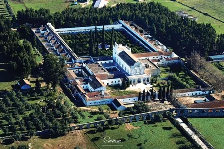 Aerial view of the historic Cartuxa Monastery surrounded by lush greenery in Évora, featured in the private tour from Lisbon.
