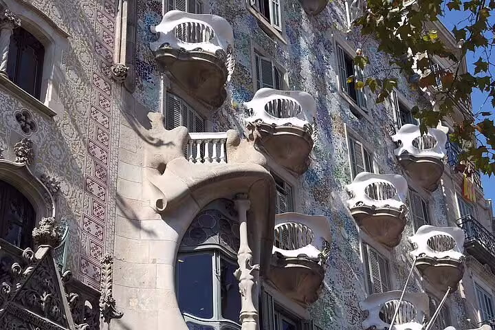 Close-up of Casa Batlló's intricate balconies and mosaic tiles, highlighting Gaudi's architectural genius and style.