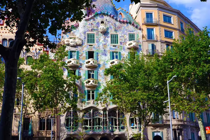 Vibrant facade of Casa Batlló, a stunning Gaudí masterpiece, in Barcelona's bustling Eixample district.