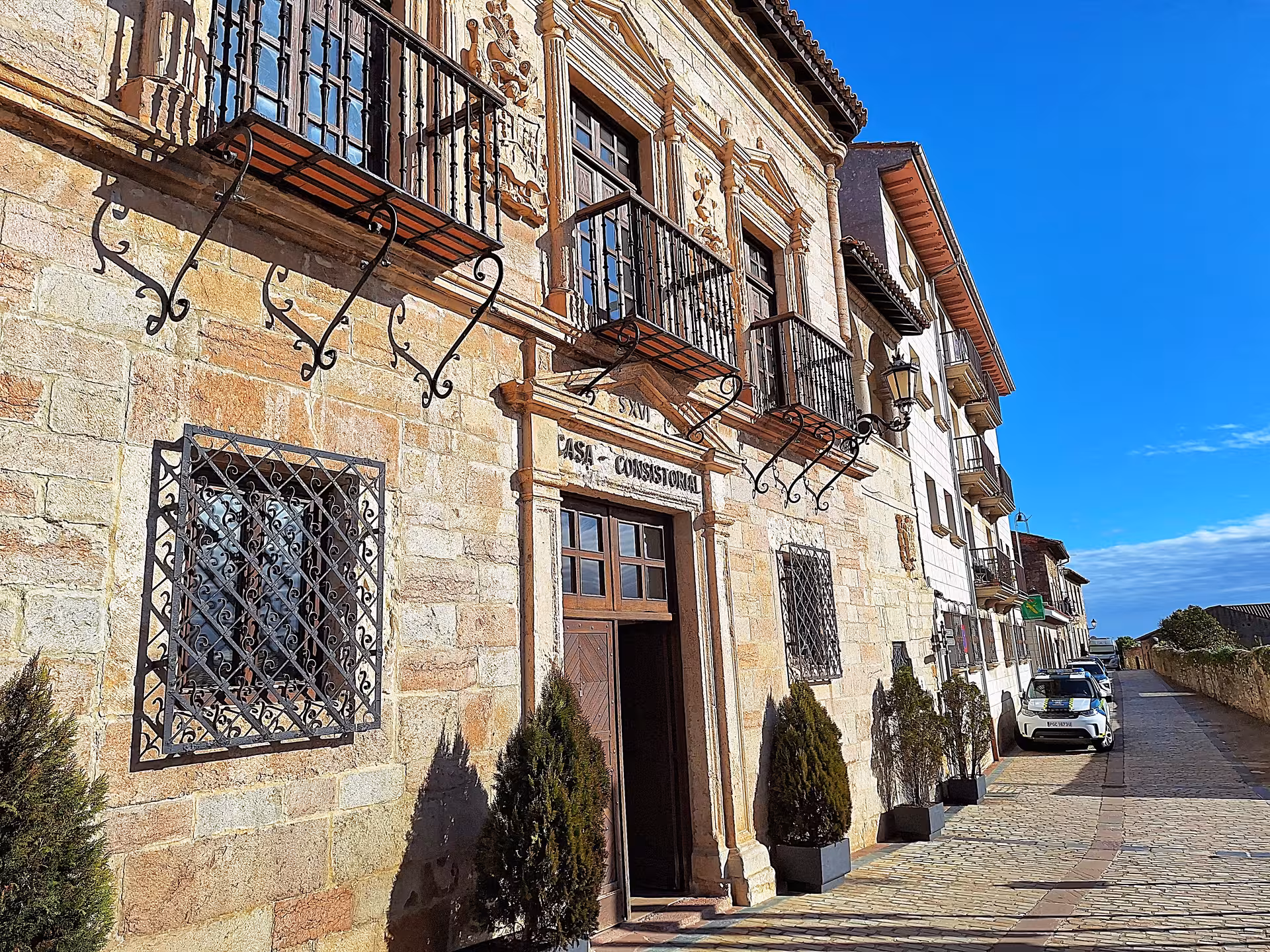 Historic architecture of Casa Consistorial in San Vicente de la Barquera, showcasing intricate balconies and stonework.