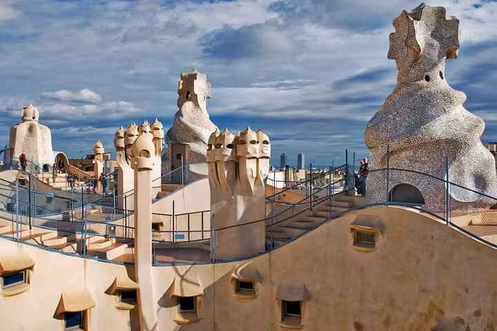 Marvel at the surreal rooftop chimneys of Casa Milà on an exclusive full-day Barcelona sightseeing tour by car.