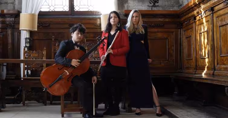 Musicians with cello and flute pose in ornate hall, setting the scene for Casanova Opera Concert at Palace of Prisons.