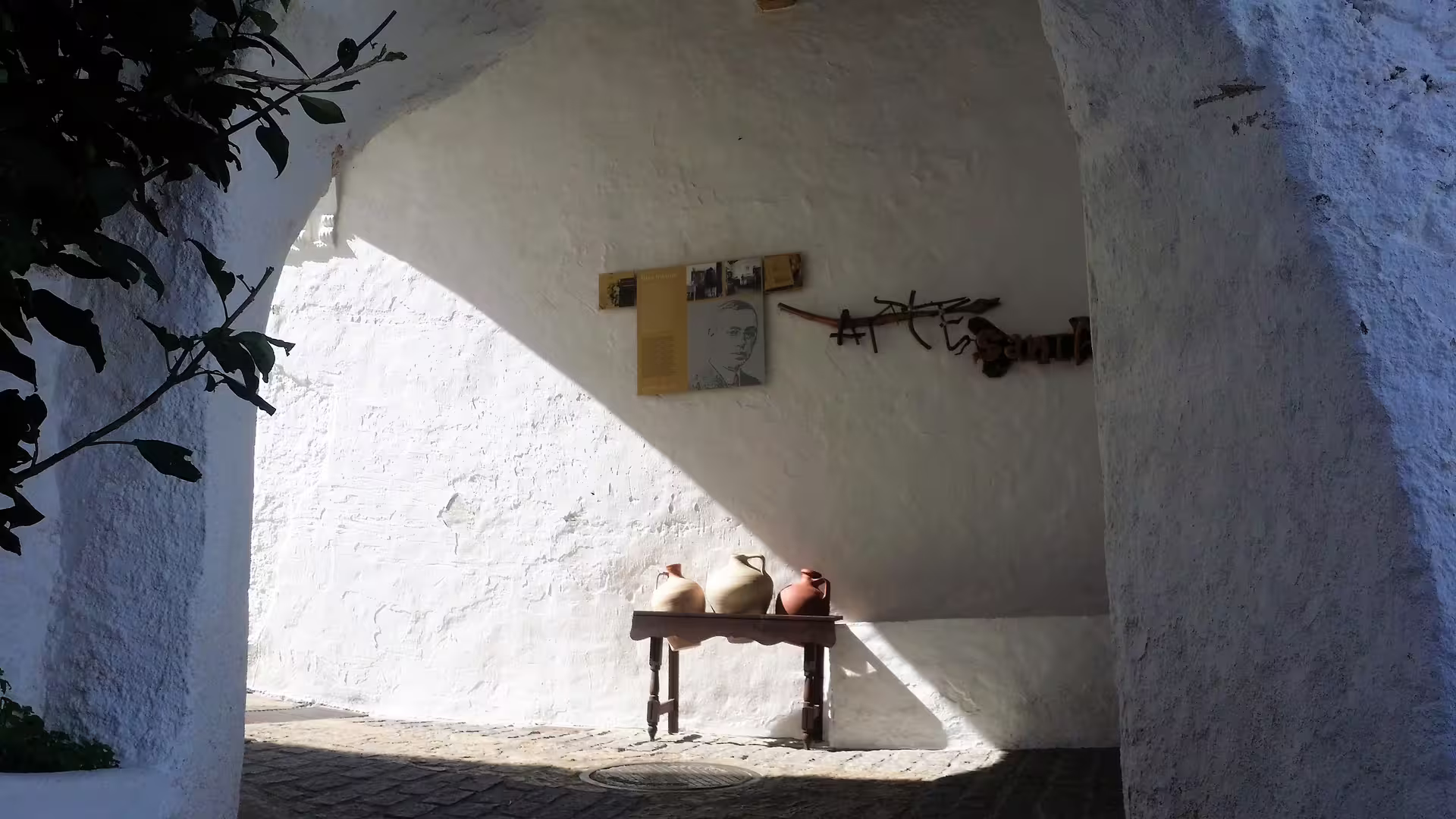 Whitewashed Casares alley corner with rustic pottery and wall art on a private tour from Costa del Sol