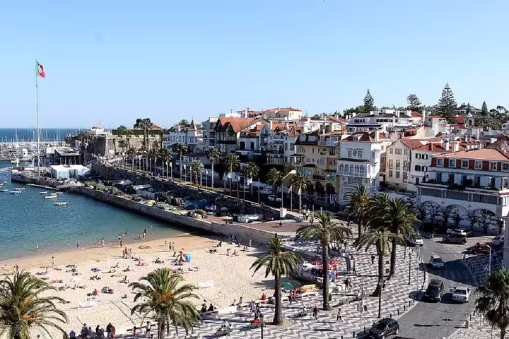 Scenic view of Cascais beach and promenade with colorful buildings, perfect for a Sintra, Cabo da Roca, and Cascais day tour.