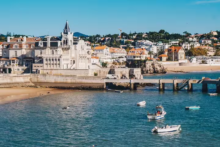 Scenic view of Cascais coastline with charming architecture and boats on the water, part of the Sintra and Pena Palace tour.