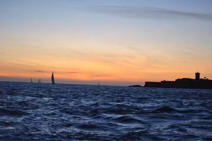 Atlantic sunset near Cascais coastline and fort silhouette, private 2h sailing cruise with drinks