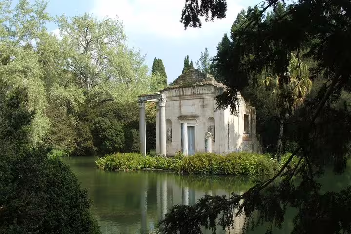Secluded lakeside temple surrounded by lush greenery in the English Garden of the Royal Palace of Caserta tour