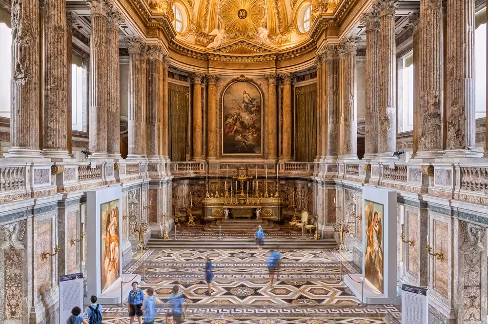 Ornate hall within Caserta Palace featuring stunning frescoes and marble columns, part of Naples cultural tour experience.