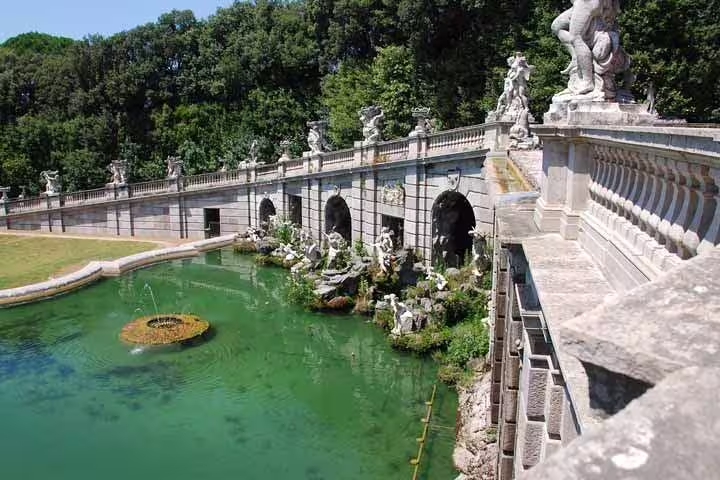 Baroque fountain, statues and emerald pool in the historic gardens of Caserta Royal Palace on a private guided tour in Campania