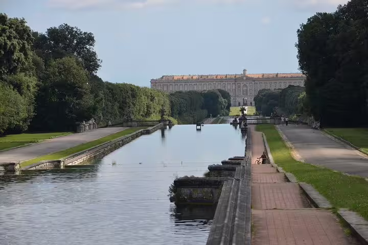 Grand canal and tree-lined avenue leading to the Royal Palace of Caserta, seen on a small-group guided walking tour