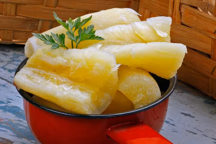 Cooked cassava served in a red pot, highlighting traditional Brazilian street food and flavors.