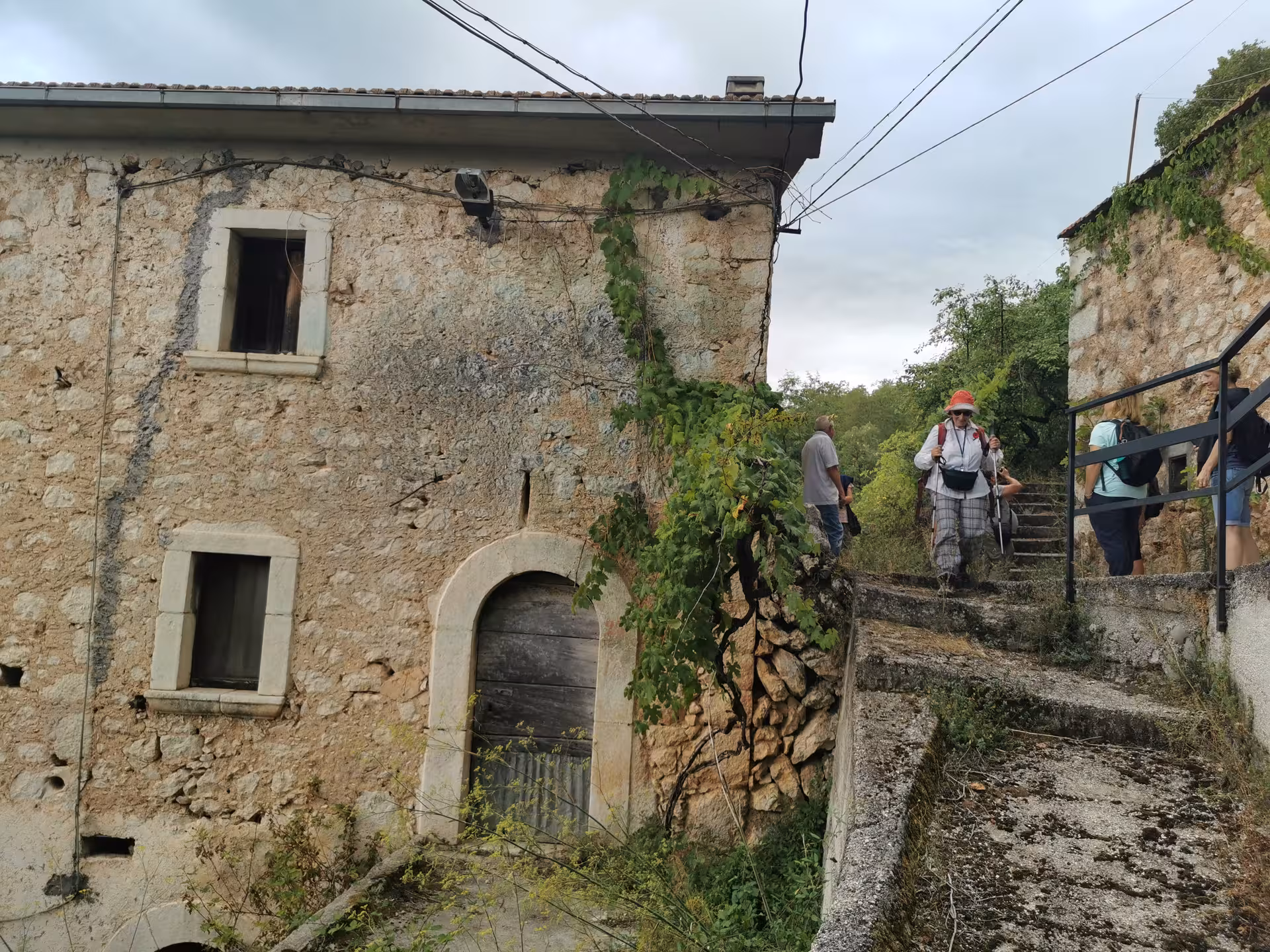 Group descends rustic stone steps in ancient Cassino village on the immersive Red Poppy walking tour.