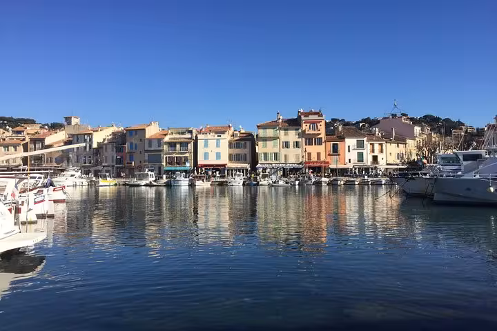 Colorful Cassis harbor with yachts and waterfront cafes, scenic stop on Cassis Bandol Le Castellet wine tour