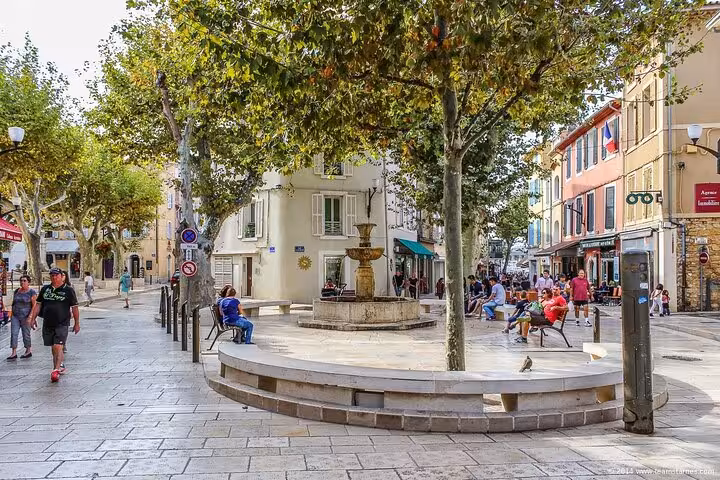 Quaint Cassis village square with a central fountain and surrounding shops, a highlight of the private tour.