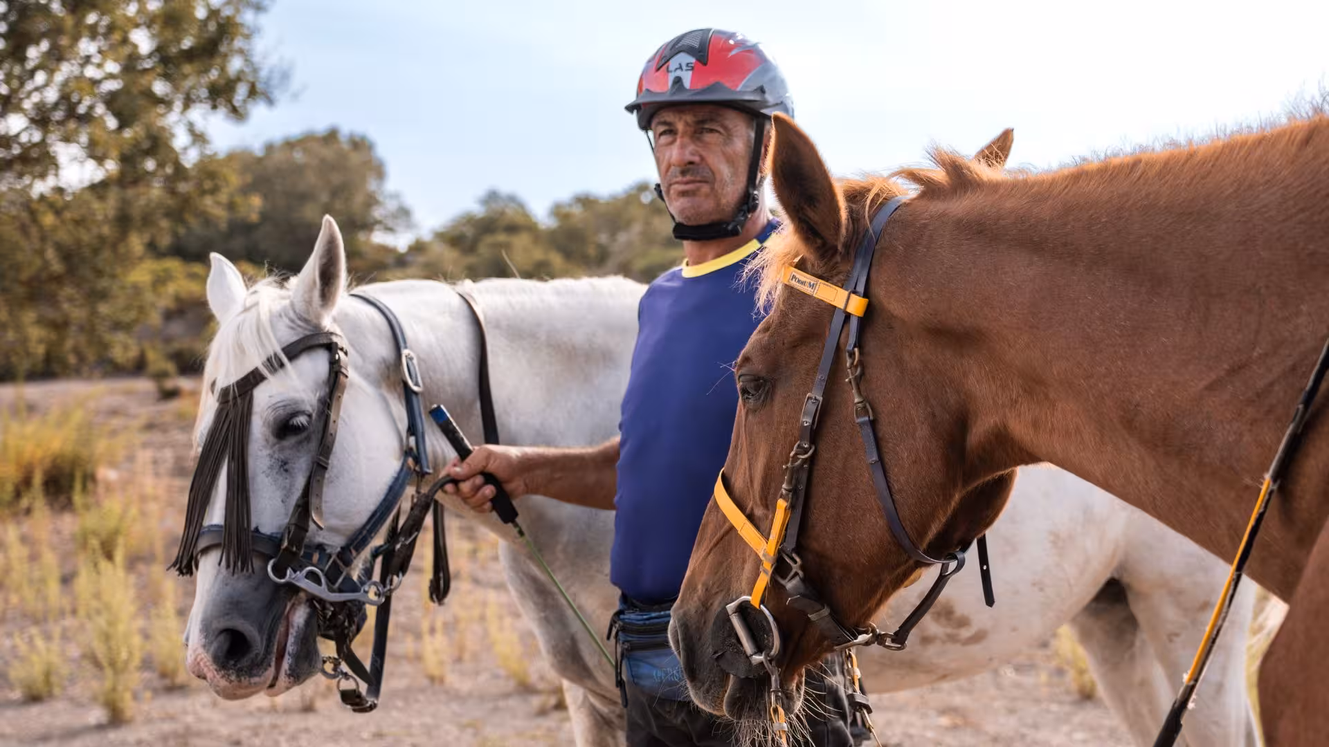 Guide with two horses in Castelsardo tour, showcasing horseback adventure in Sedini's scenic landscapes.
